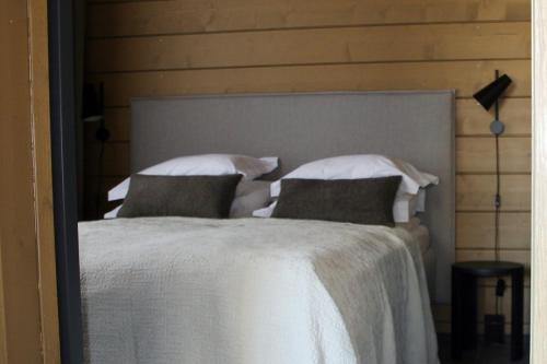 a bedroom with a bed with white sheets and pillows at Levin Lyhty Bettina by Hilla Villas in Kittilä
