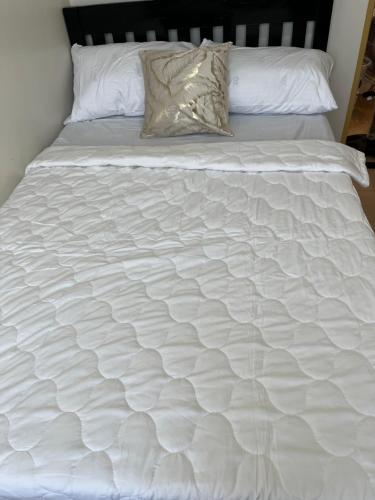 a white bed with white sheets and pillows on it at 2 Bedrooms Budget Friendly Condotel in Iloilo City in Iloilo City