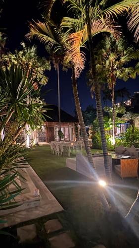 a resort yard with palm trees and a fountain at Kudus Boutique Hotel in Canggu 100m to Beach in Canggu