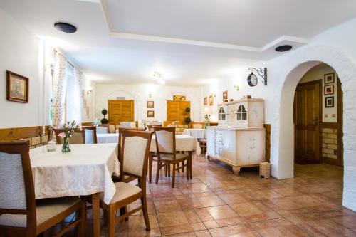 a dining room with white tables and chairs at Villa Cynamon in Wisła