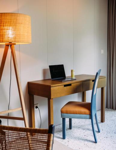 a desk with a laptop on it with a chair at NEXT - by Savoy Signature in Funchal