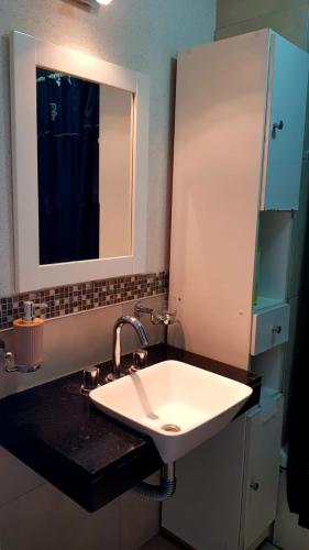 a bathroom with a white sink and a mirror at Frente al Mar con cochera in Miramar