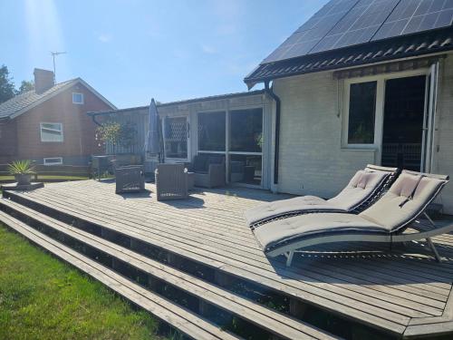 a wooden deck with two chairs on a house at Sjönära villa in Oskarshamn