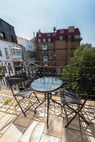 a glass table and chairs on a balcony at Central Dayflat Apartments in Kyiv
