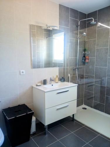 une salle de bain avec un lavabo blanc et une douche dans l'établissement Cigales, à Belcodène