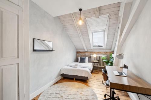 a attic bedroom with two beds and a desk at The R Loft - Cosy Hostel, Communal Bathroom and Kitchen in Olten