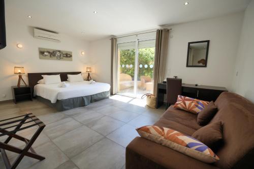 un salon avec un lit et un canapé dans l'établissement Hotel U Paesolu, à Sainte-Lucie de Porto-Vecchio