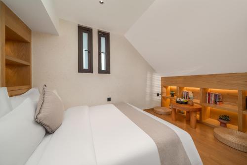 a bedroom with a large white bed and a desk at Chongqing Xiannv Mount Peach Blossom Spring Homest in Wulong