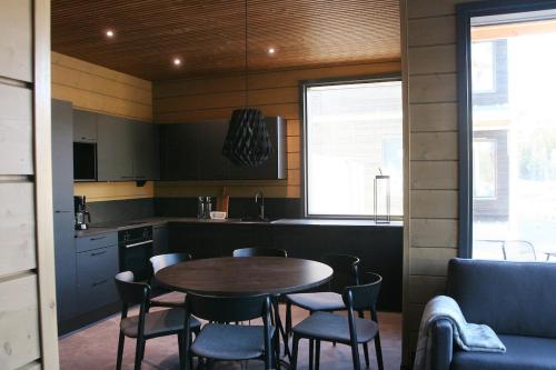 a kitchen with a table and chairs in a room at Levin Lyhty Bella by Hilla Villas in Kittilä