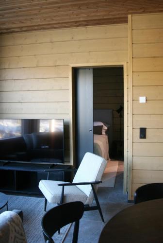 a living room with a couch and a bed at Levin Lyhty Bella by Hilla Villas in Kittilä