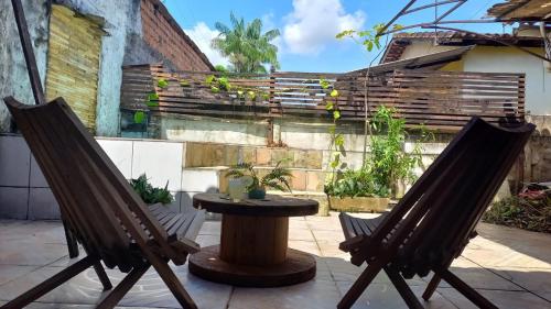 Dos sillas y una mesa en un patio. en Casa COP30, en Ananindeua