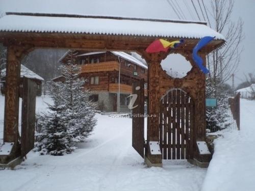 a wooden gate with snow on top of it at Pensiunea Simina in Vişeu de Jos