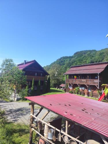 a large red picnic table in front of a building at Pensiunea Simina in Vişeu de Jos