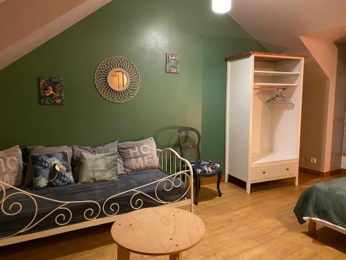 a living room with a couch and a green wall at Lannion city center apartment in Lannion