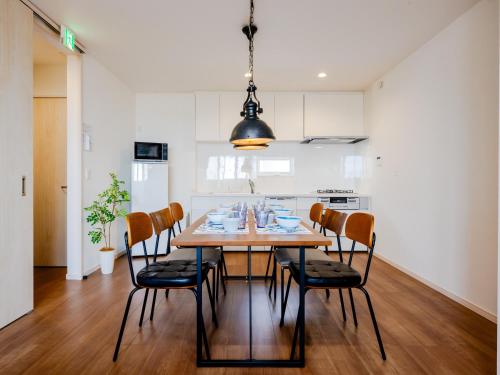 a kitchen and dining room with a wooden table and chairs at Town House Suma in Kobe