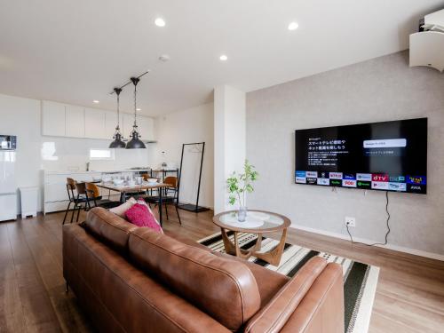 een woonkamer met een bank en een eetkamer bij Town House Suma in Kobe
