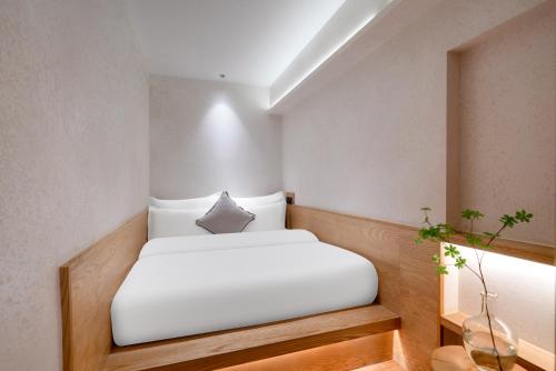 a bedroom with a white bed in a room at Chongqing Xiannv Mount Peach Blossom Spring Homest in Wulong