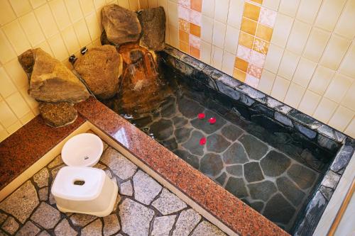 a bathroom with a bath tub with a toilet at 寝室から太平洋を望む貸切別荘in海友荘 無料炭火BBQスペースと駐車場付 in Shirahama