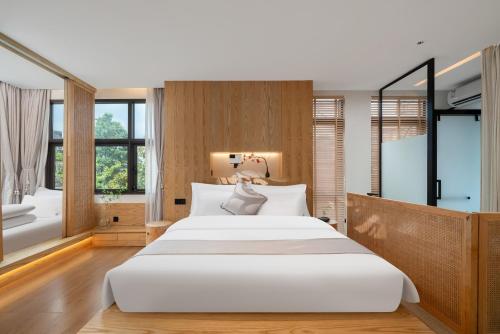 a bedroom with a large white bed and a tub at Chongqing Xiannv Mount Peach Blossom Spring Homest in Wulong