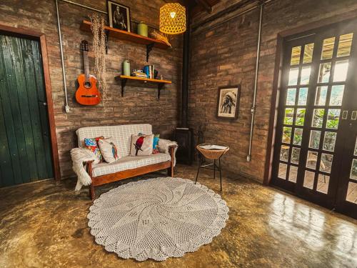 a living room with a couch and a guitar at Sítio Passarim in São Francisco Xavier
