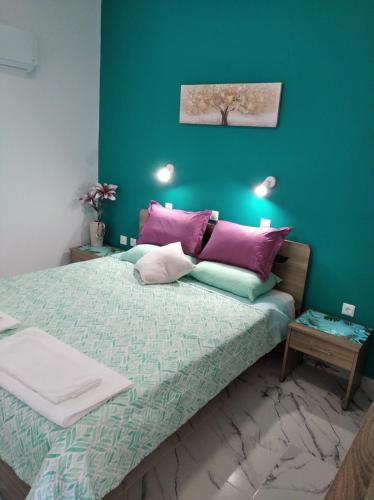 a bedroom with a large bed with purple pillows at Apollon Stegna Studios in Archangelos