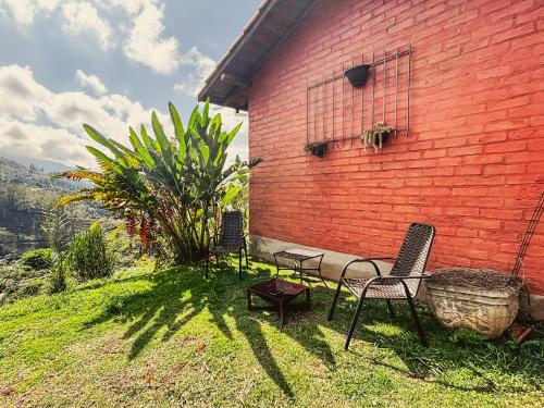 a red brick building with chairs and a table at Sítio Passarim in São Francisco Xavier