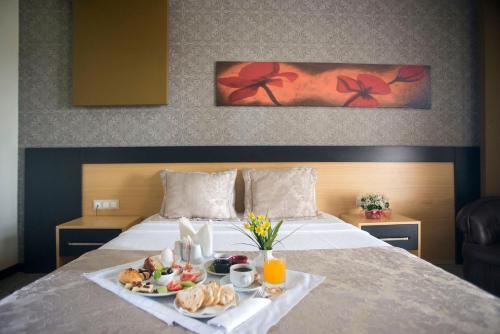 a hotel room with a tray of food on a bed at Berksoy Hotel in Bergama