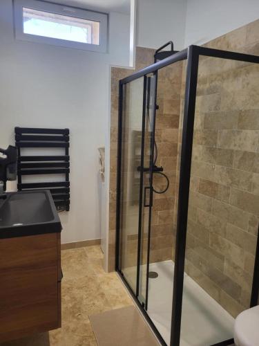 a bathroom with a glass shower with a sink at Les échappées de Senonches in Senonches