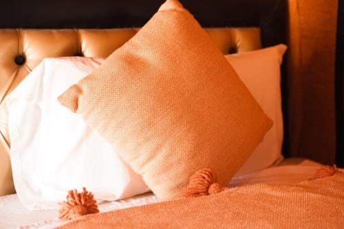 a pillow on a bed with white pillows at Sahara Luxurious Tented in Merzouga