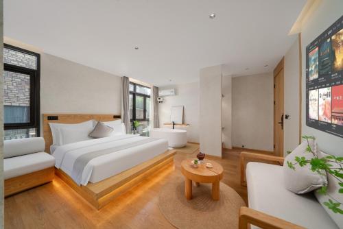 a bedroom with a bed and a couch and a table at Chongqing Xiannv Mount Peach Blossom Spring Homest in Wulong