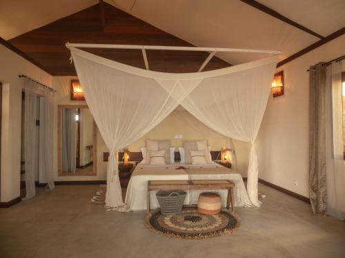 a bedroom with a bed with a canopy at Natiora Green Lodge in Sainte Marie