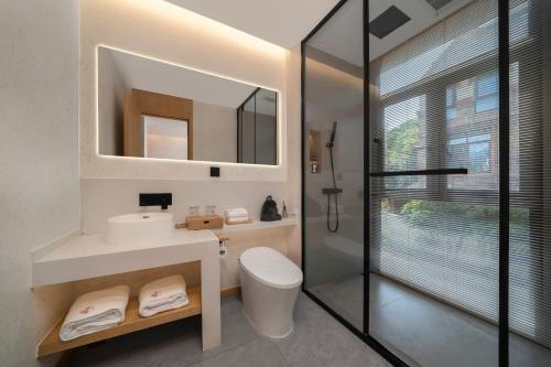 a bathroom with a toilet and a sink and a shower at Chongqing Xiannv Mount Peach Blossom Spring Homest in Wulong