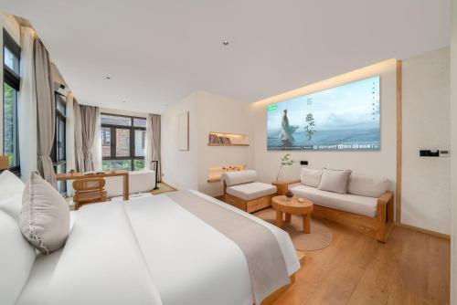 a bedroom with a large bed and a living room at Chongqing Xiannv Mount Peach Blossom Spring Homest in Wulong