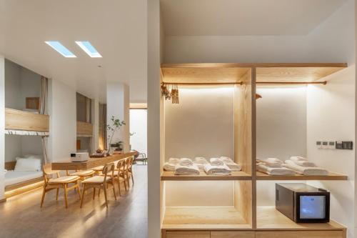 a room with a table and chairs and a television at Chongqing Xiannv Mount Peach Blossom Spring Homest in Wulong