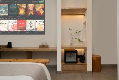 a bedroom with a bed and a desk with a tablet at Chongqing Xiannv Mount Peach Blossom Spring Homest in Wulong