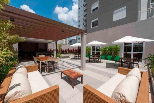 a patio with chairs and tables and umbrellas at Excelente Studio a 3 quadras da Avenida Paulista in Sao Paulo