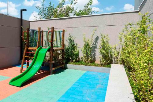a playground with a green slide in a backyard at Excelente Studio a 3 quadras da Avenida Paulista in Sao Paulo