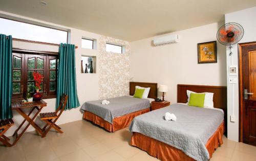 a hotel room with two beds and a window at Cat Tien Jungle Lodge in Cat Tien