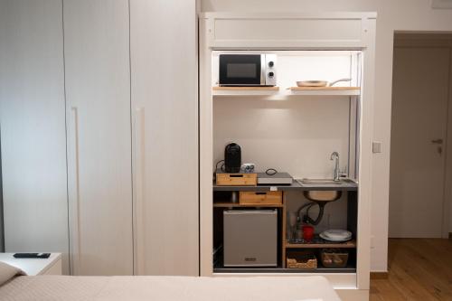 a room with a bed and a kitchen with a microwave at G&G Luxury Rooms in Bari