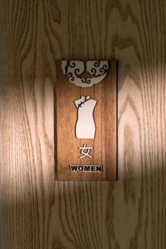 a sign on a wall with a mannequin on it at Chongqing Xiannv Mount Peach Blossom Spring Homest in Wulong