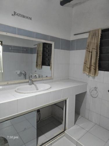 a bathroom with a sink and a mirror at Starehe Luxury B & B in Malindi