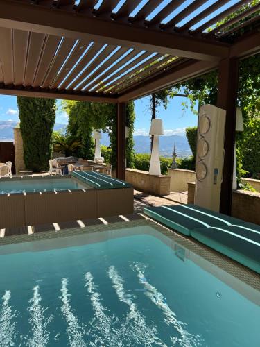 an outdoor swimming pool with a pergola and a swimming poolvisor at Palazzo Bontadosi Hotel & Spa in Montefalco