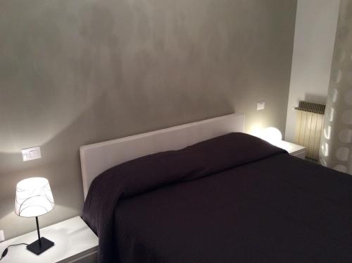 a bedroom with a black bed and two lamps at Le Stanze di Theia in Chianciano Terme