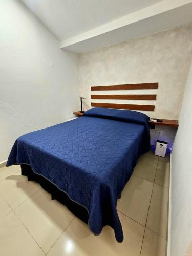 a bedroom with a bed with a blue comforter at Villa Leo in Cancún