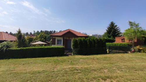 una casa con una recinzione in un cortile di Domek letniskowy nad morzem a Jarosławiec