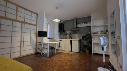 a living room with a kitchen and a table with a fan at Charme Ticinese Navigli house e free wifi in Milan