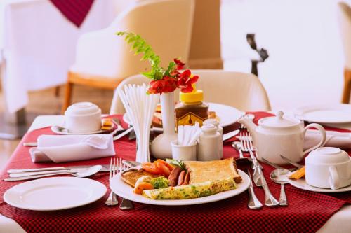 a table with a plate of breakfast food on it at Tanga Beach Resort & Spa in Tanga