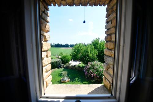 a view of a garden from a window at Le Mas Des Aigras - Hôtel & Restaurant de Charme en Provence in Orange