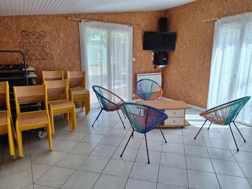 ein Wohnzimmer mit bunten Stühlen und einem Tisch in der Unterkunft Détente à la campagne in Cossé-le-Vivien