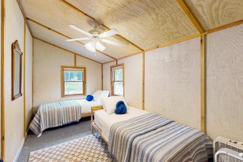 a room with two beds and a ceiling fan at Catfish Cottage B in Eagle River